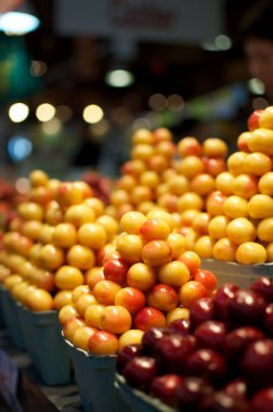 Pazar yerinde sarı Rainier kirazı ve kızılcık meyvelerinin seçici odak noktası.