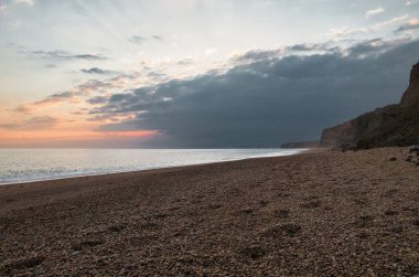Denizin üzerindeki altın gün batımının büyüleyici görüntüsü