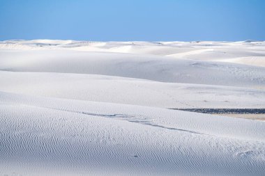 Güneşin altında beyaz kumlardan oluşan güzel bir manzara.
