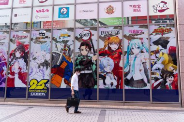 Akihabara, Japonya- 7 Ağustos 2020: Bir adam Akihabara 'da dekore edilmiş bir alışveriş merkezinin yanında yürüyor.