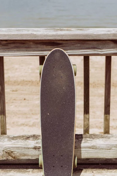Ένα Κάθετο Κοντινό Πλάνο Ενός Skateboard Ακουμπισμένο Ένα Ξύλινο Φράχτη — Φωτογραφία Αρχείου