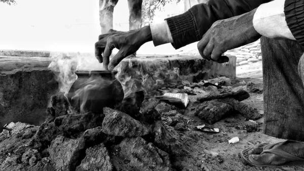 土鍋でご飯を炊いて煙を上げている男がいて インドの農村部ではよく見られる調理法である — ストック写真