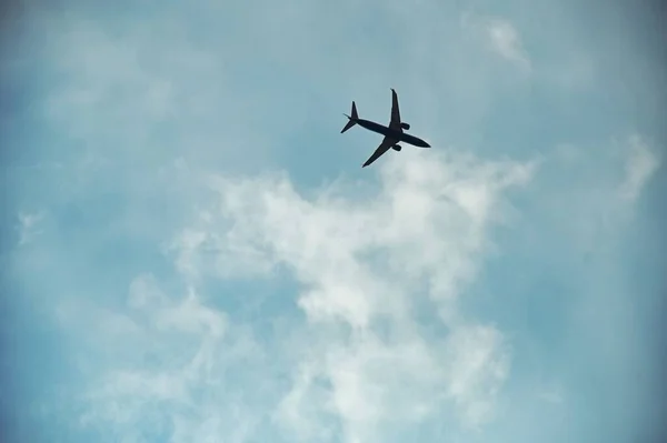 Mavi Bulutlu Gökyüzünde Uçan Bir Uçağın Alçak Açılı Görüntüsü — Stok fotoğraf