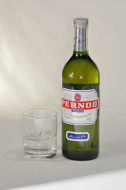 Bir şişe Pernod Fransız likörü ve bir stüdyoda cam bardak.