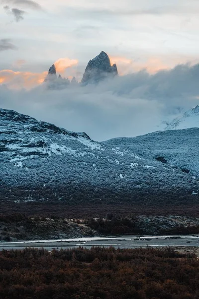 Sisin Içinde Gizlenen Karla Kaplı Dağların Dikey Görüntüsü — Stok fotoğraf