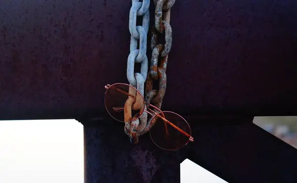 Close Óculos Castanhos Pendurados Uma Corrente Enferrujada Azul — Fotografia de Stock