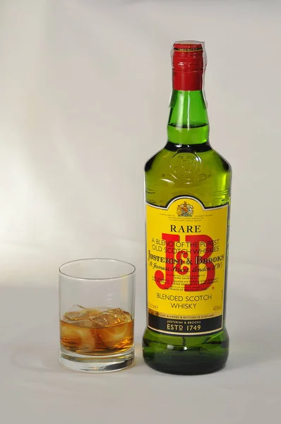 スタジオでのボトルとJ Bのカップの垂直ショット珍しいスコッチウイスキー — ストック写真