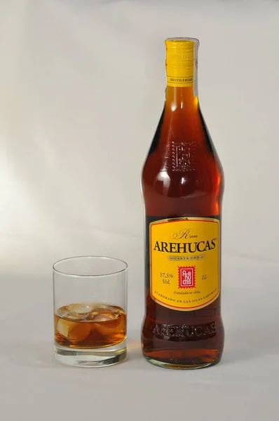 在演播室里 一个瓶子和一杯阿雷胡卡朗姆酒的垂直镜头 — 图库照片