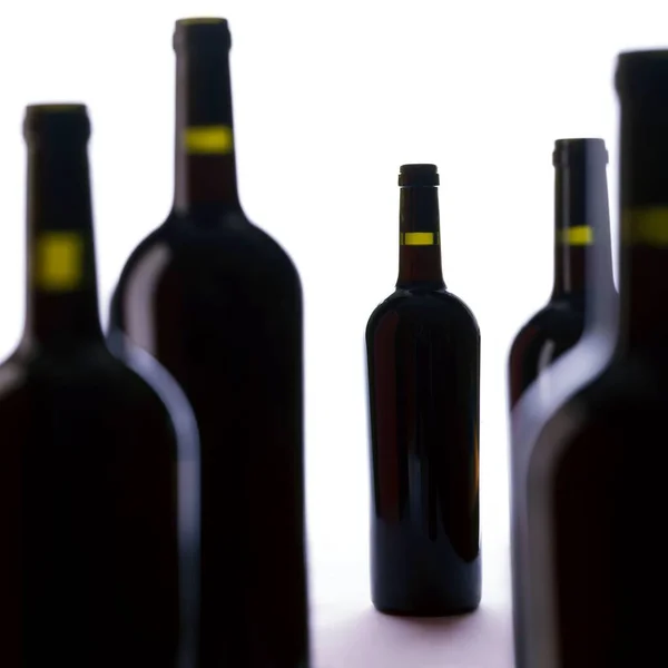 Μια Ομάδα Από Πέντε Μπουκάλια Κρασιού Λευκό Φόντο Επικεντρώνεται Ένα — Φωτογραφία Αρχείου