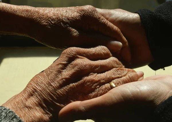 Yaşlı Bir Kadının Ellerini Elinde Tutan Bir Adamın Yakın Çekimi — Stok fotoğraf