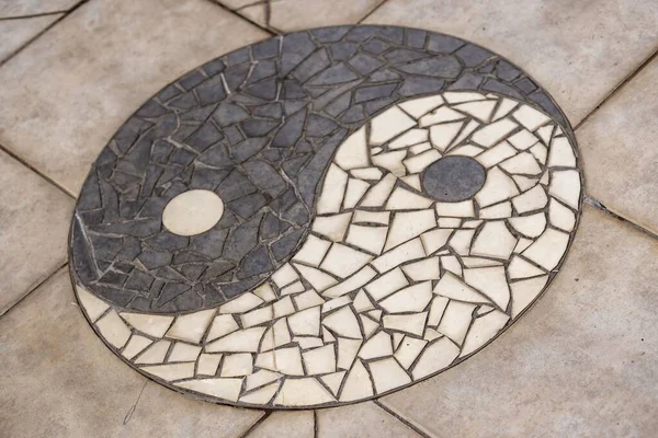 A Yin Yang symbol mosaic on a tiles floor