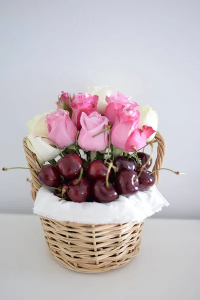 Вертикальный Снимок Разноцветных Роз Вишни Корзине Белом Столе — стоковое фото