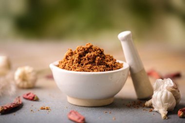 Kahverengi baharatlı ve kirli mutfak masasında bir topuz bulunan bir havan topunun yakın çekimi.