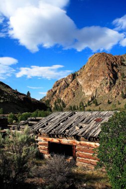 Idaho, ABD 'de arka planda manzaralı dağları olan terk edilmiş bir çiftlik.