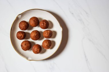 Ev yapımı kahverengi çörekler ve fotokopi alanı olan beyaz bir tabağın üst görüntüsü.