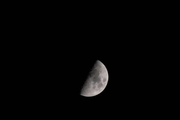 半明半暗的月亮映衬着夜空 — 图库照片
