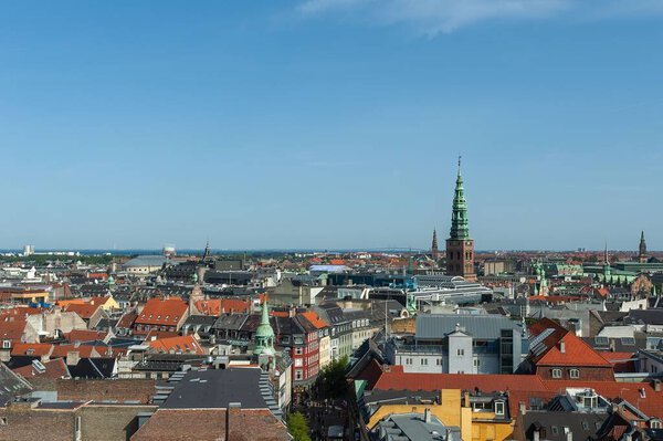 A rooftop view of Copenhagen cityscape against blue sky background in Denmark