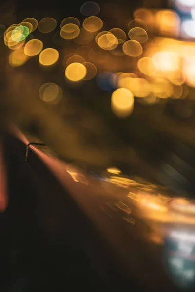 A vertical shot of golden bokeh lights on a blurry background
