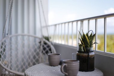 İki kahve fincanı ve sandalyeli beyaz renkli modern bir balkon.