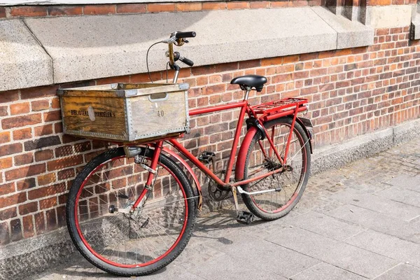 一辆红色的金属自行车 街道上有一个旧的木制篮子 靠着砖墙 — 图库照片