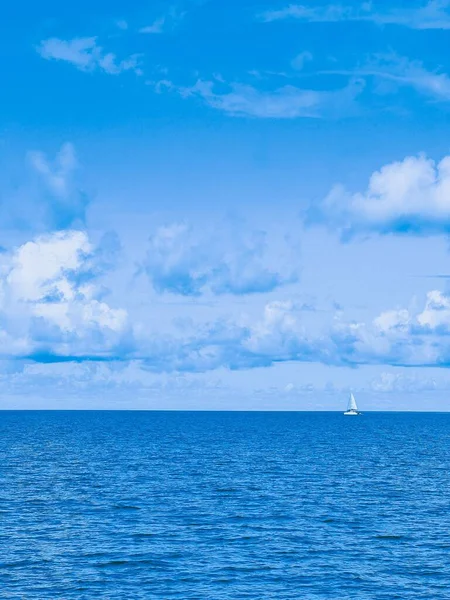 Mavi Sularda Yüzen Beyaz Bir Teknenin Dikey Görüntüsü — Stok fotoğraf
