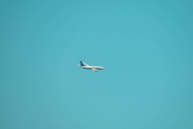 Mavi gökyüzüne karşı uçan bir uçağın görüntüsü