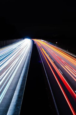 Karayolu trafiğinin dikey görüntüsü. İki yönlü yoğun otoyolda trafik ışıkları ışık çiziyor.