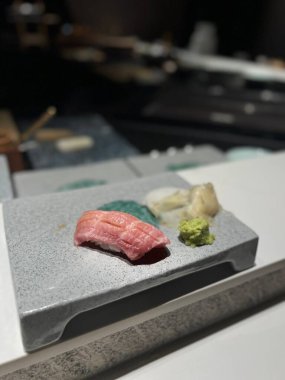 Gri taş bir tahtanın üzerinde wasabi ve Sushi 'nin yakın çekimi.