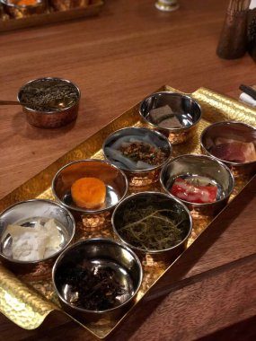 Lezzetli farklı yemeklerden oluşan yakın plan bir kafedeki ahşap masa üzerindeki küçük tabaklar.