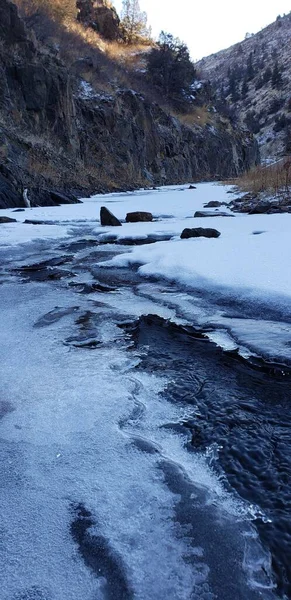 Tiro Vertical Água Corrente Cercada Pelo Solo Coberto Gelo Neve — Fotografia de Stock