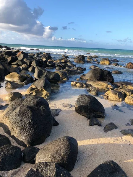 在沙滩上垂直拍摄的大石头 背景是平静的海浪 — 图库照片