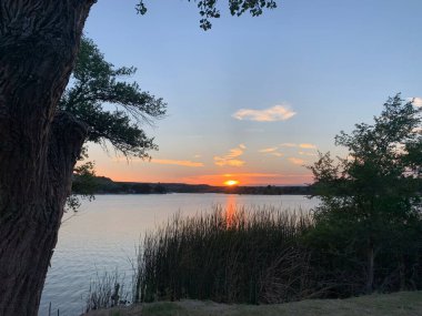 Gün batımının altında sakin bir göl.