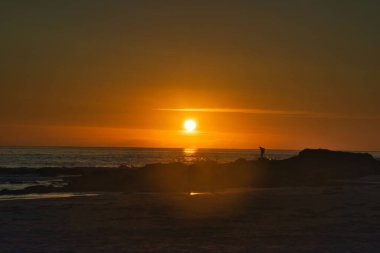 Kuzey Norveç 'teki Lofoten adalarında gece yarısı güneşinin canlı bir manzarası.
