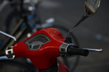 Yakın çekim sapları ve kırmızı bir motosikletin hız gösterge paneli.