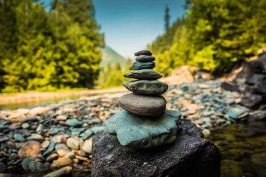 Arka planda bulanık ağaçlarla dışarıda taş istiflemenin sığ bir odağı