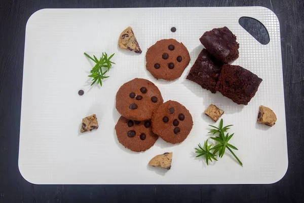 Verschillende Koekjes Brownies Geserveerd Wit Bord Met Decoratieve Planten — Stockfoto