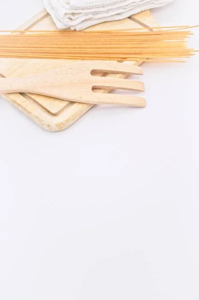 有機農業スパゲティ木のまな板フォーク白いテーブルの上のキッチンクロス — ストック写真