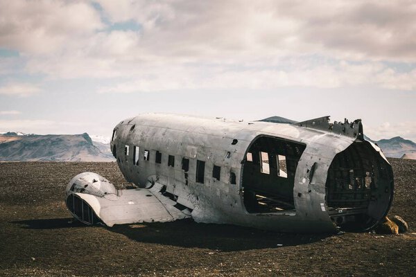The wreckage of the crashed airplane in Solheimasandur, Iceland under a bright cloudy sky