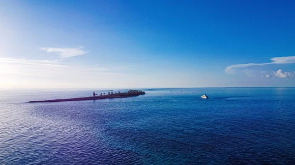 The Bahamas island with lighthouse and superyacht on the horizon