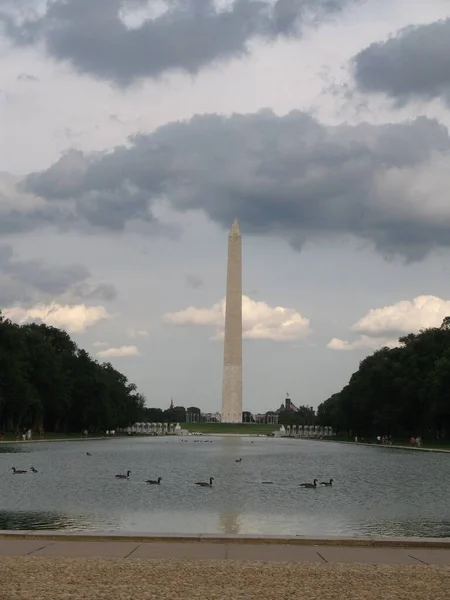 林肯纪念堂反射池上方的华盛顿纪念馆景观 池中有鸭子 天空中也有云彩 — 图库照片