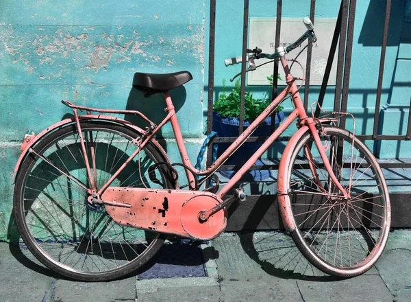 Uma Bicicleta Vermelha Enferrujada Apoiada Parede Azul Edifício Portão Metal — Fotografia de Stock