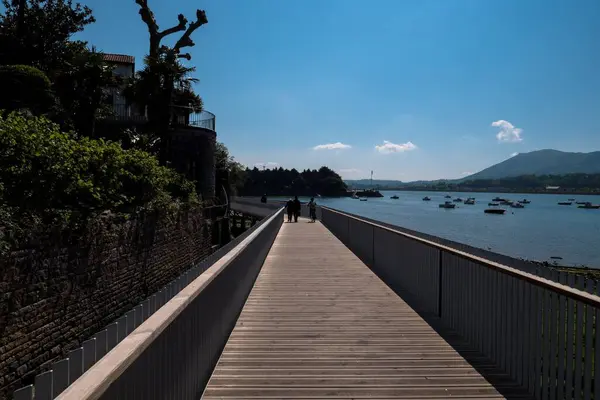 晴れた日には橋の歩道を海で歩く人々 — ストック写真