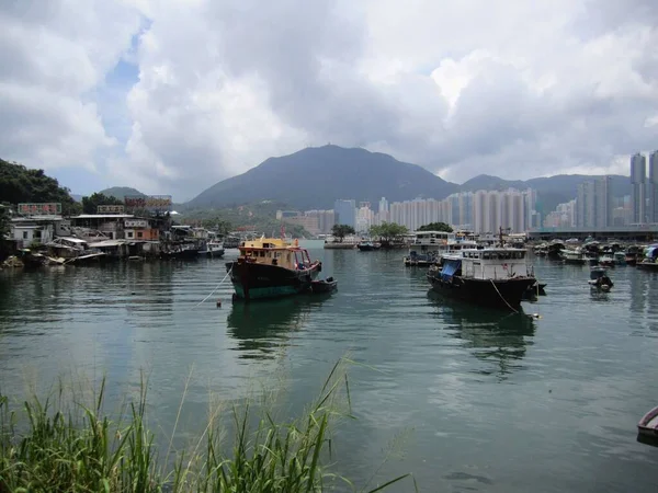 在多云的天空背景下 一个小镇上的小舟在河上航行的风景 — 图库照片