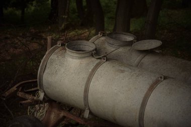 Ormandaki eski paslı su tanklarının yakın çekimi.