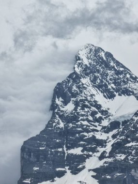 Karlı bir Eiger Dağı 'na yakın, bir tarafı tamamen bulutlarla kaplı.
