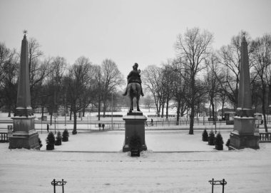 Kış günü bir parktaki binicilik anıtının gri tonlu bir görüntüsü.