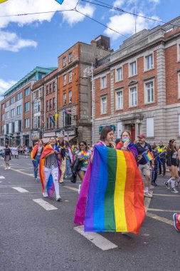 İrlanda, Dublin 'deki Onur Festivali' nde gökkuşağı bayraklarıyla yürüyen bir grup insan