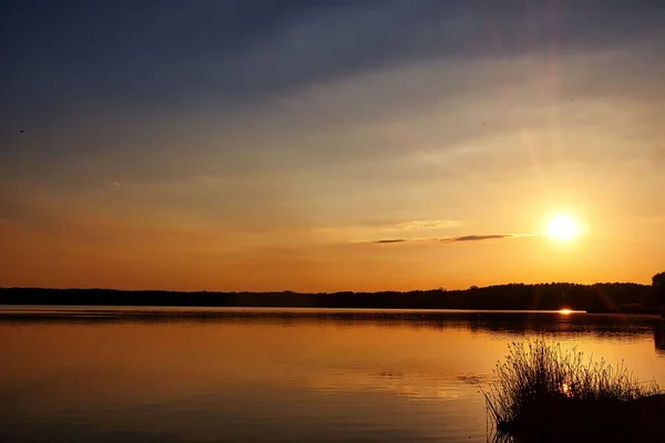 背景には湖とシルエットの丘の上に美しい夕日のシーン — ストック写真