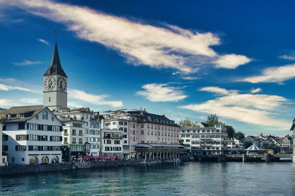 The embankment of the Limmat river with St. Peter Church in the background, Zurich, Switzerland