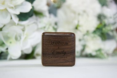William ve Emily için oyulmuş ahşap bir alyans kutusunun yakın çekimi.